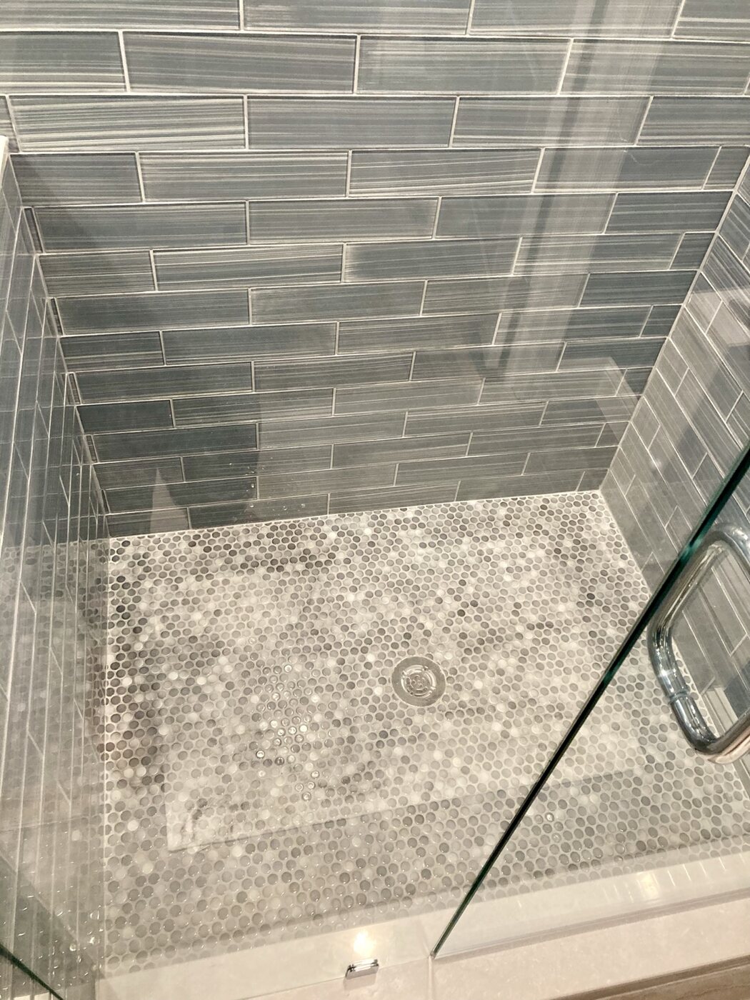 Bathroom 2 shower floor and linear blue wall tile