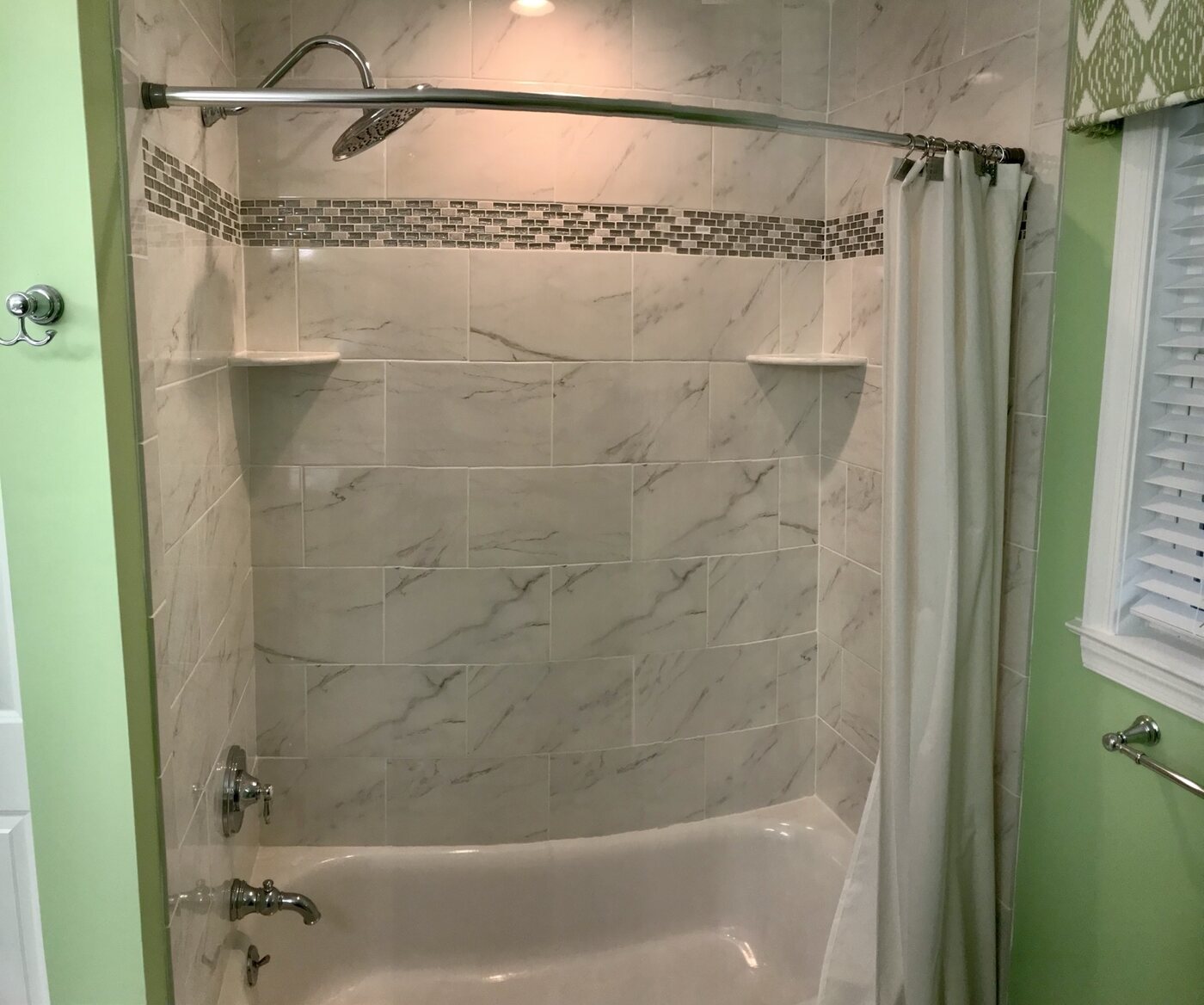 Bathroom 5 marble-look tiled tub with mosaic accent band