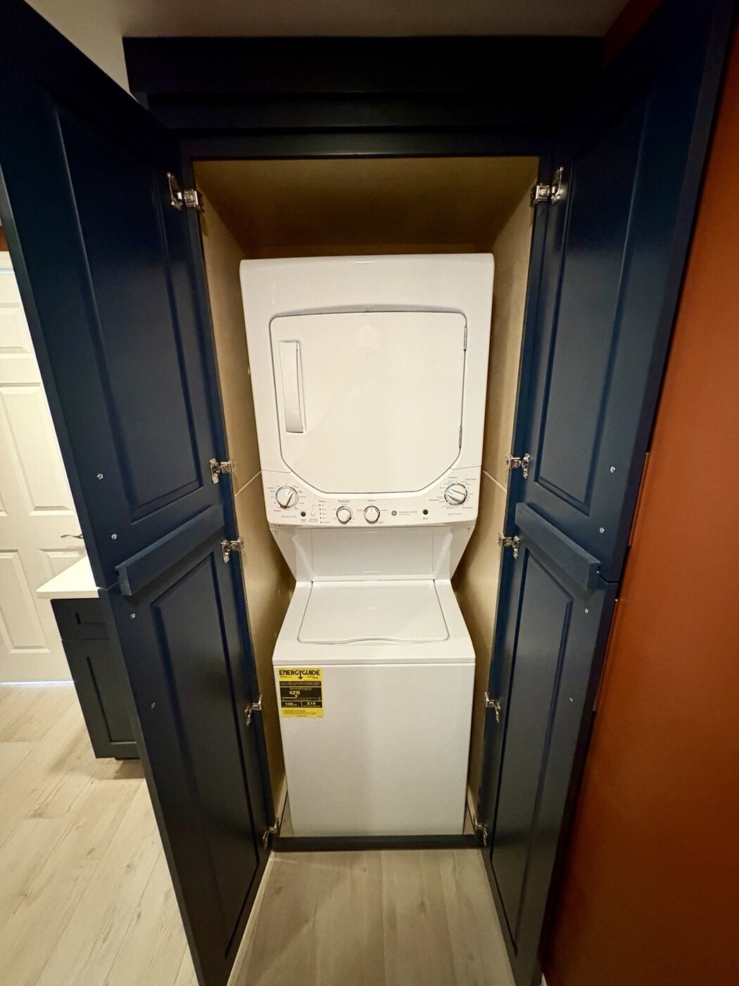 Laundry appliances concealed inside custom navy cabinetry