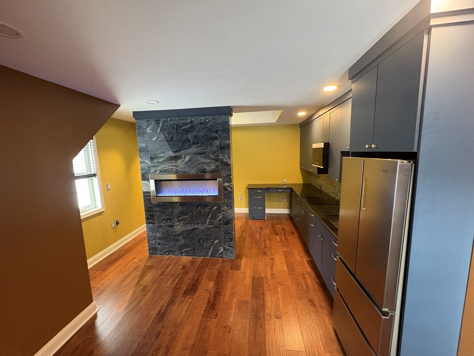 Completed Antler Drive garage conversion with kitchen, living area, and fireplace