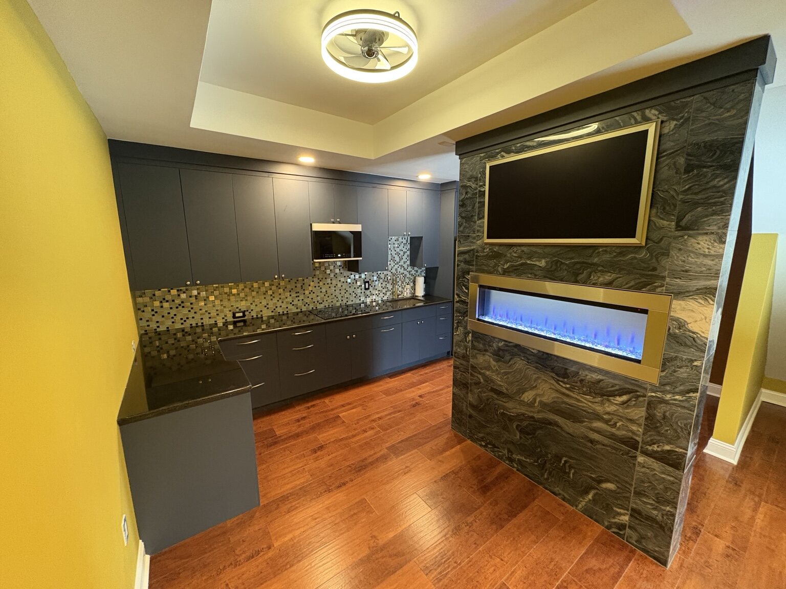 Finished kitchen with full-size refrigerator and dark cabinetry