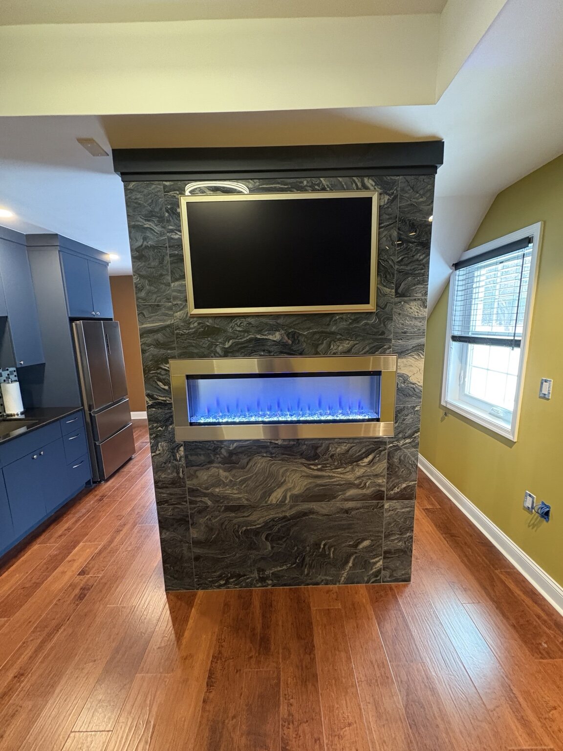 Kitchen cabinetry, refrigerator, and wood flooring