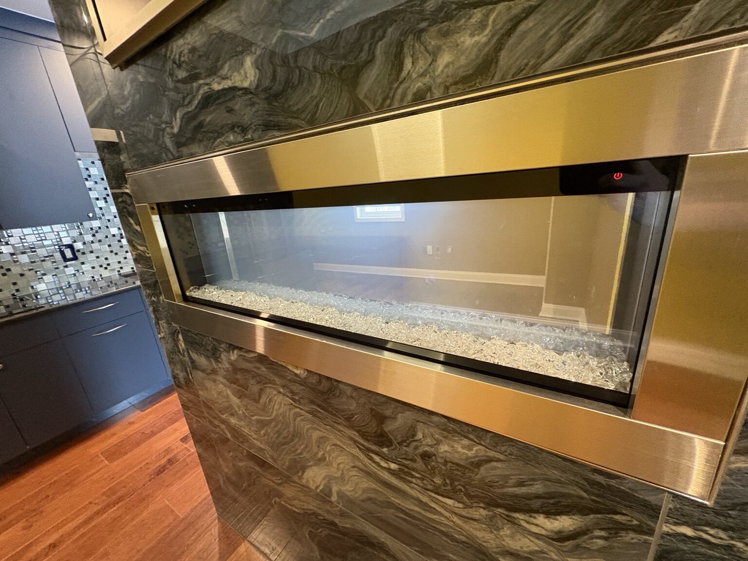 Completed kitchen with cabinetry, backsplash, and wood flooring