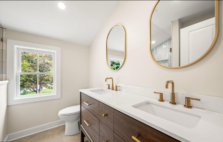 Full bathroom with double vanity and brushed brass fixtures