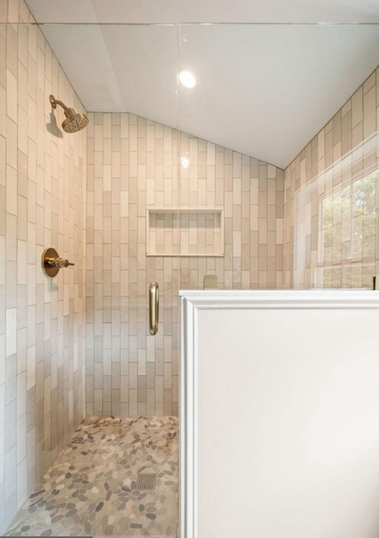 Walk-in shower with vertical tile and pebble floor