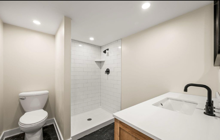 Full bathroom with walk-in shower and wood vanity