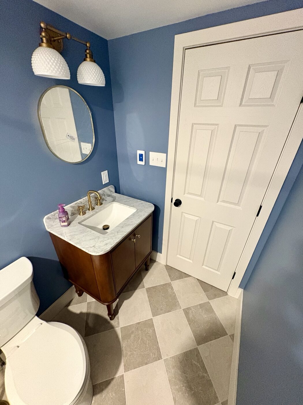 Bathroom vanity with rounded stone top and vintage-inspired lighting