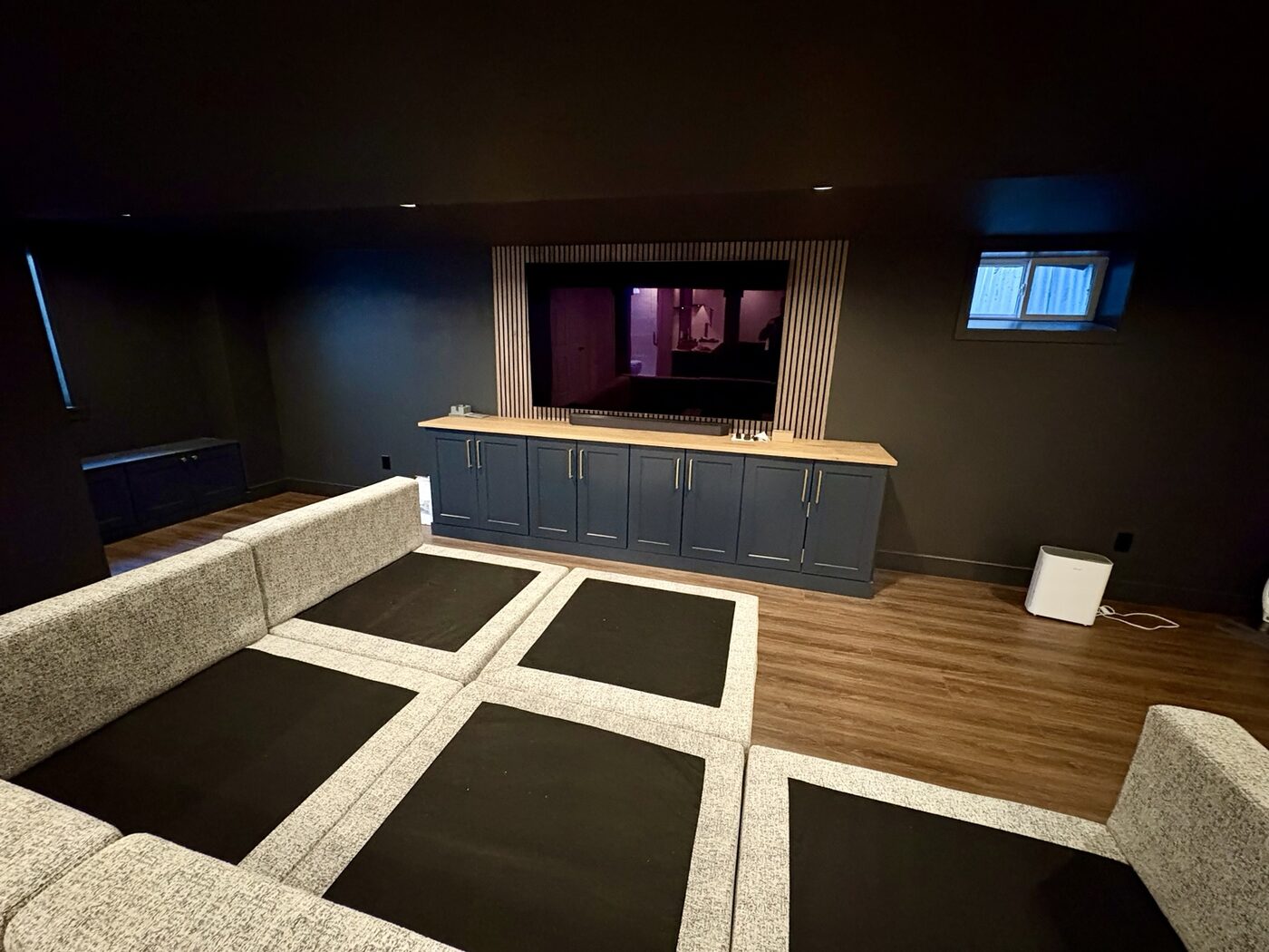 Custom media wall with slat surround and built-in cabinetry