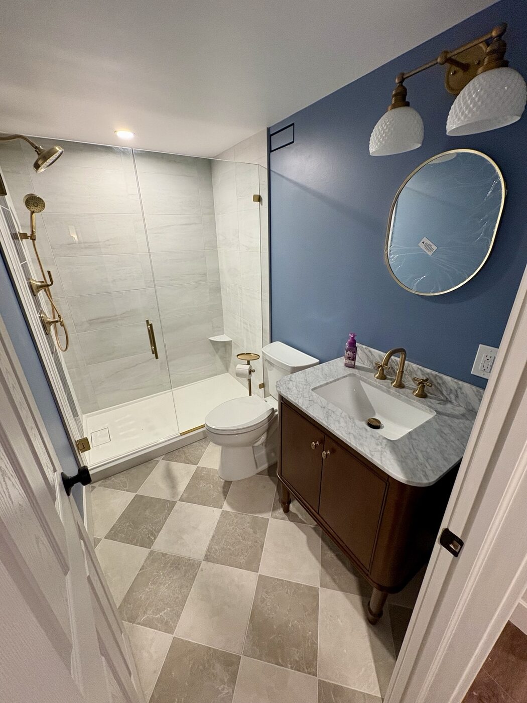 Basement bathroom with furniture-style vanity and brass fixtures