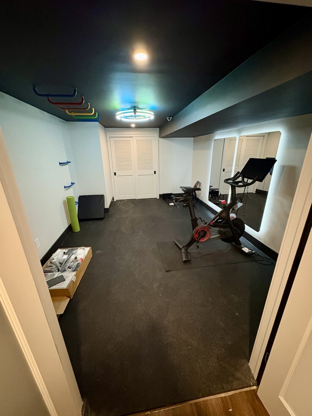 Home gym with illuminated mirrors and dark ceiling